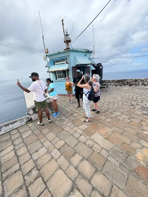 Guests taking photos at a hilltop fort overlooking the sea