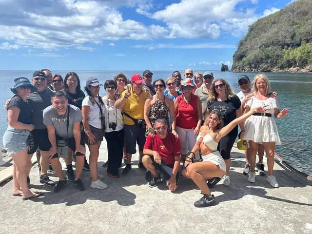 Large tour group smiling on the jetty with the bay behind them